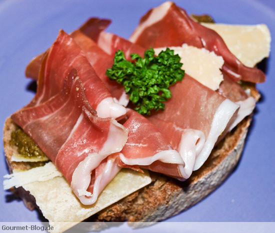 Steinofenbrot mit Rucolapesto - Parmaschinken und Parmesanspänen belegt