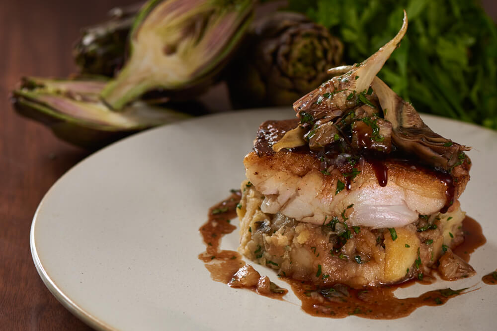 Roasted cod with crushed potatoes, artichoke, salted capers and a red wine lemon sauce