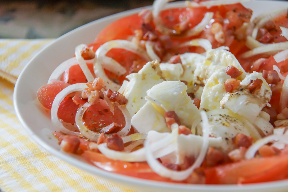 Tomaten-Mozzarella Salat mit Speckwürfeln und Zwiebeln - Rezept