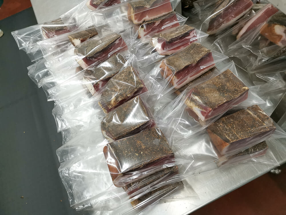 Speck aus Südtirol - Speck Stücke werden vakuumiert